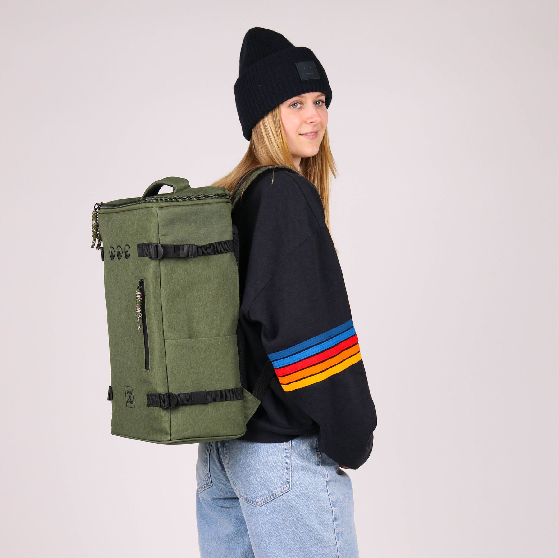 Studiobild Frau traegt hybrid 2in1 Rucksack in olive-gruen und Trolley auf dem Rucücken