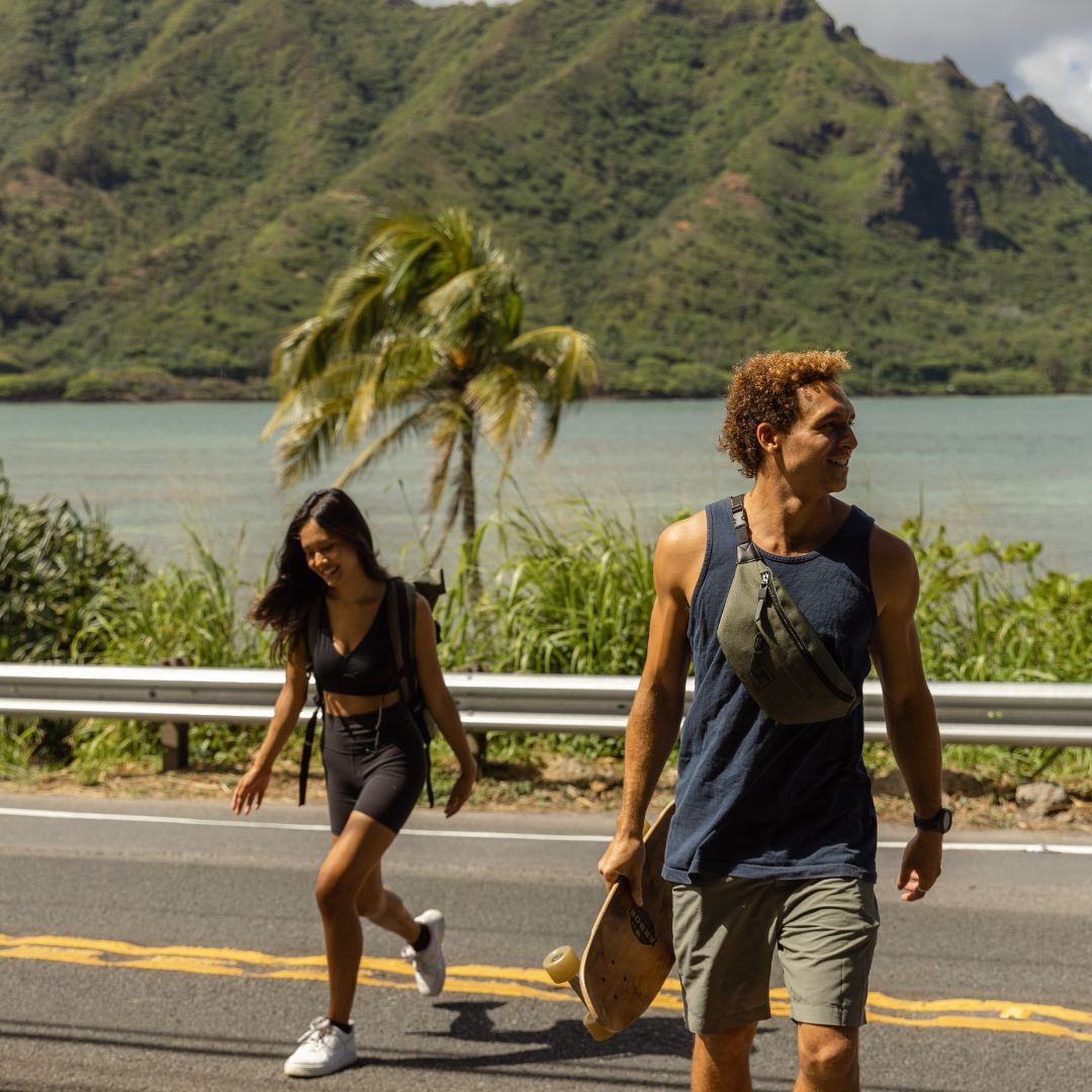 SONS OF ALOHA Bild in Thailand am Meer Mann in kurzen Hosen  mit einer Bauchtasche umgehängt