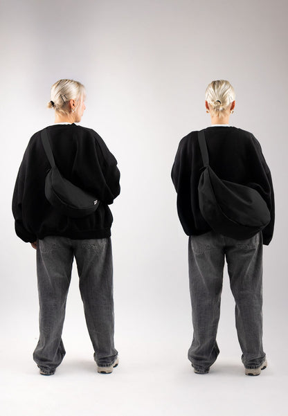 Moon bag schwarz XL inuse indoor frau steht mit dem ruecken zur kamera weite jeans