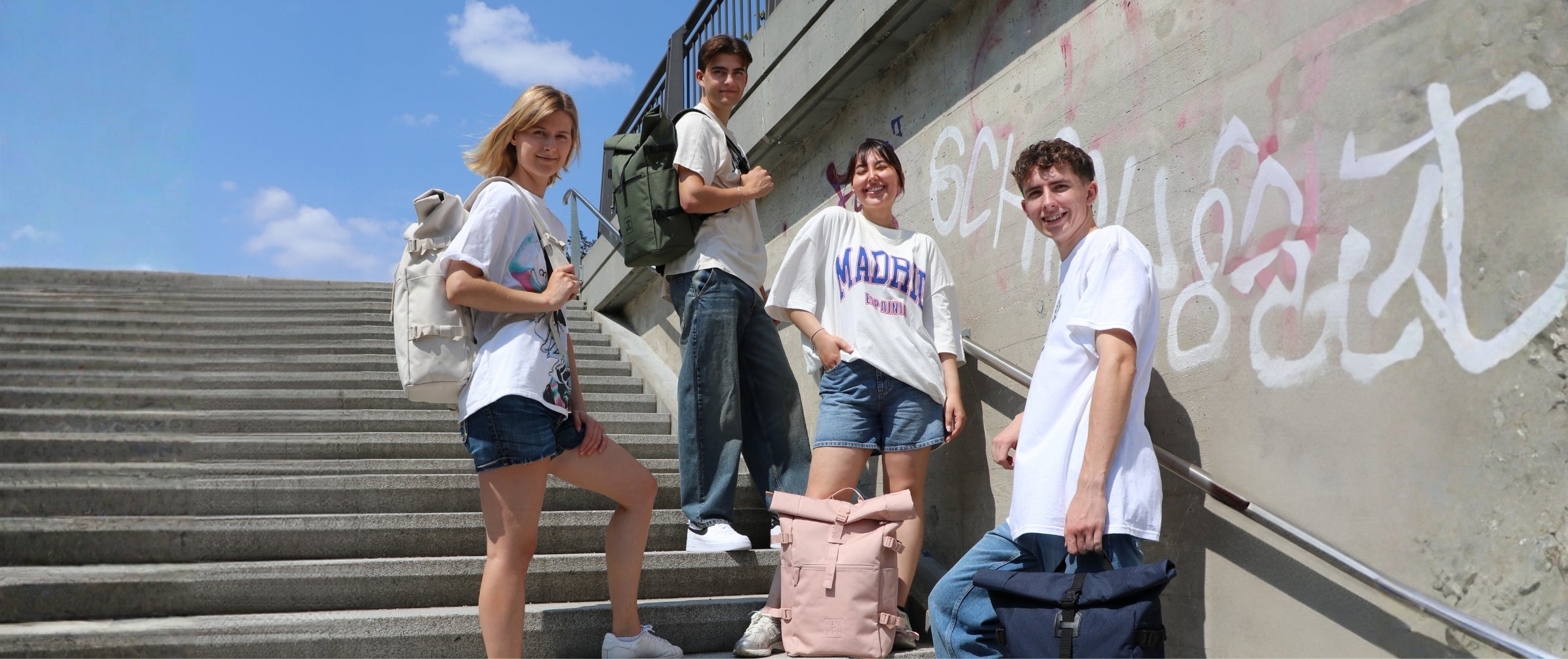 Back to School Bild mit 4 Uni Studenten und ihren Rucksäcken in beige, olive, rosa und navy.