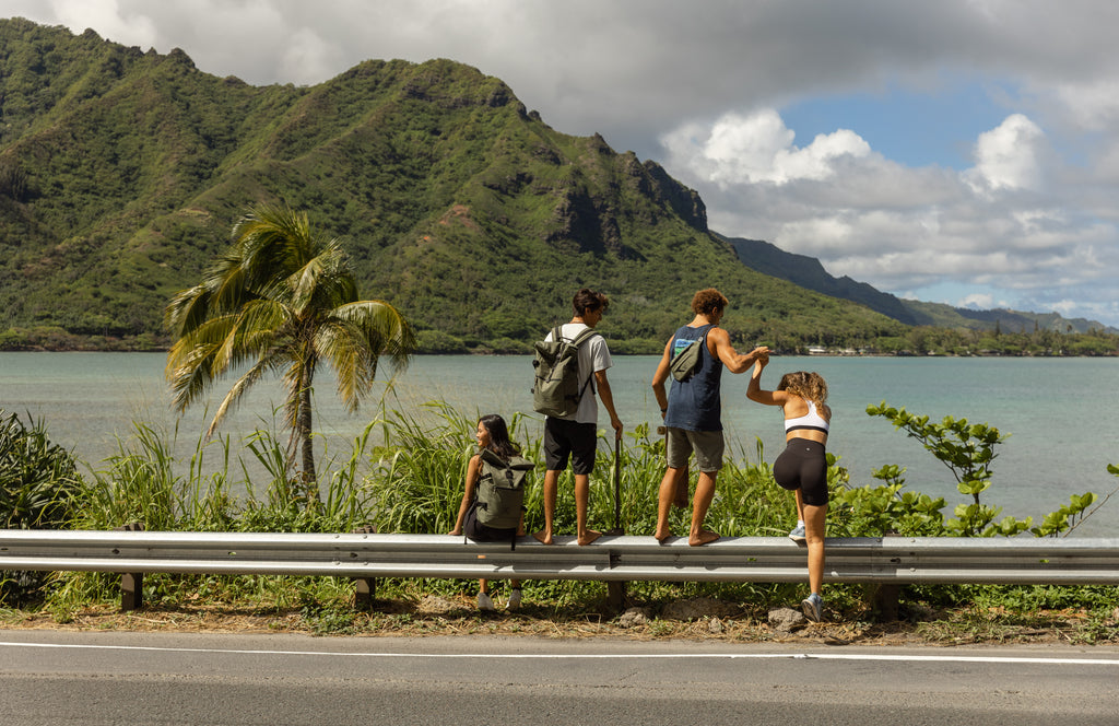 Group of 4 people sitting on the side of a tropical road